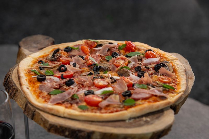 Veggie supreme pizza loaded with roasted vegetables and pesto